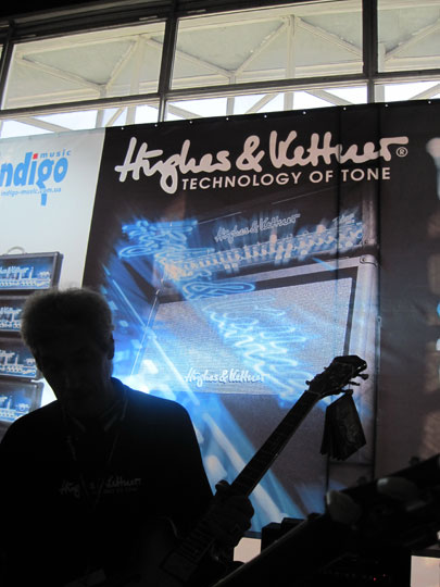 На фоне банера Hughes&Kettner. Муз.Ярмарка 2010. г. Киев.